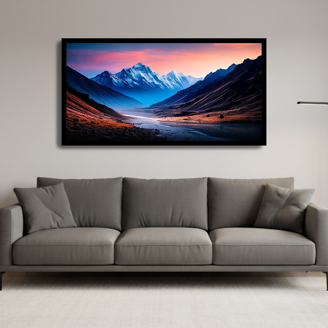 Framed mountain landscape painting above a gray sofa in a living room.