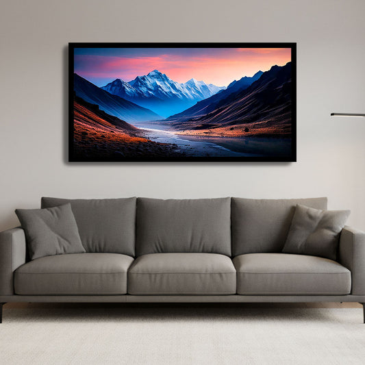 Framed mountain landscape painting above a gray sofa in a living room.